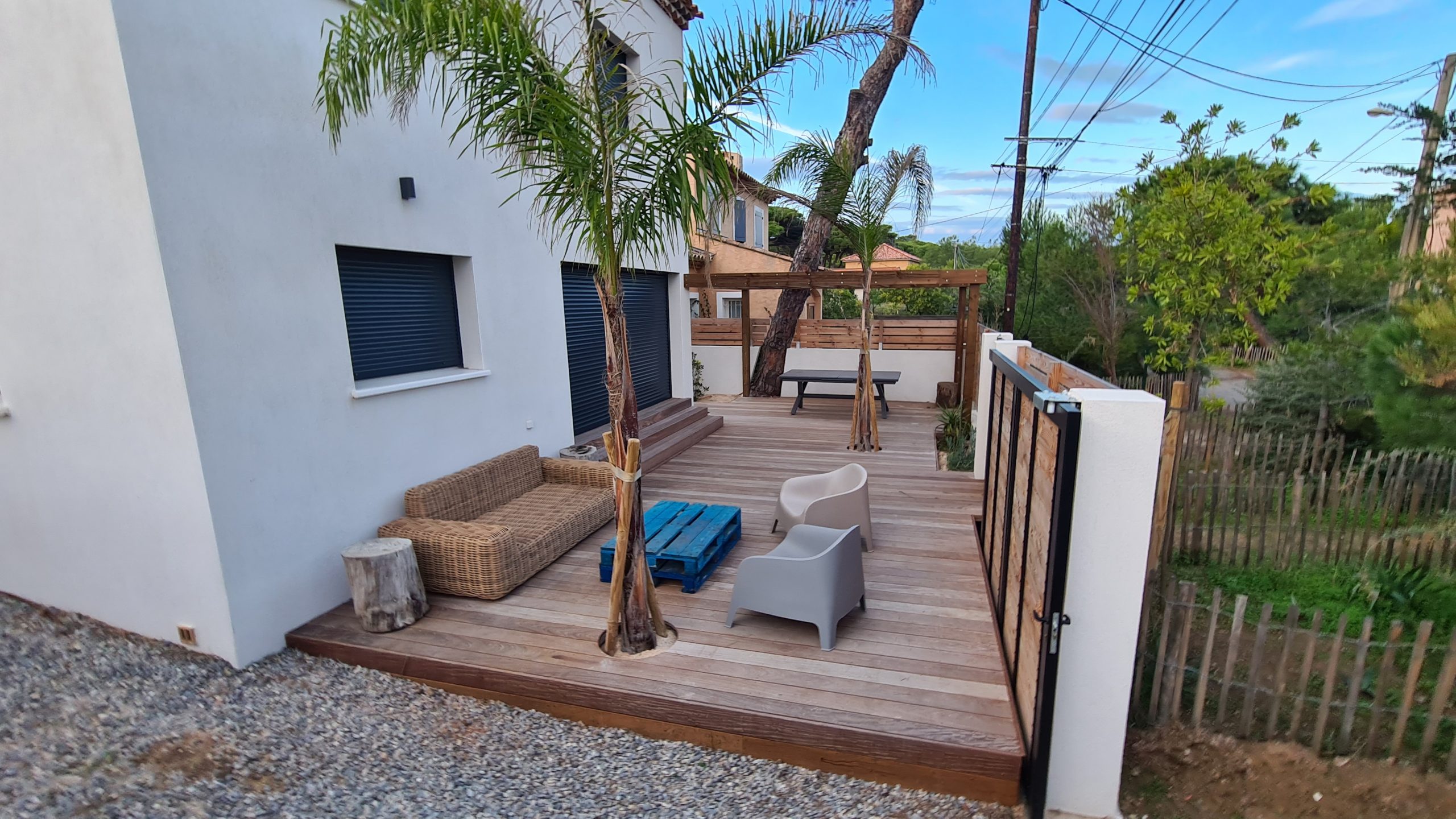 Arbres de taille moyenne au sein d'une terrasse en bois avec une pergolas