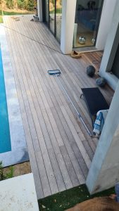 Terrasse en bois avec piscine dans une villa, vu de haut, zoom sur le parquet