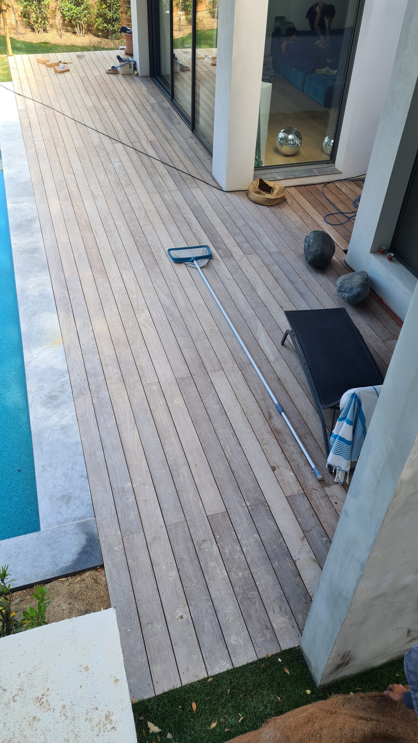 Terrasse en bois avec piscine dans une villa, vu de haut, zoom sur le parquet