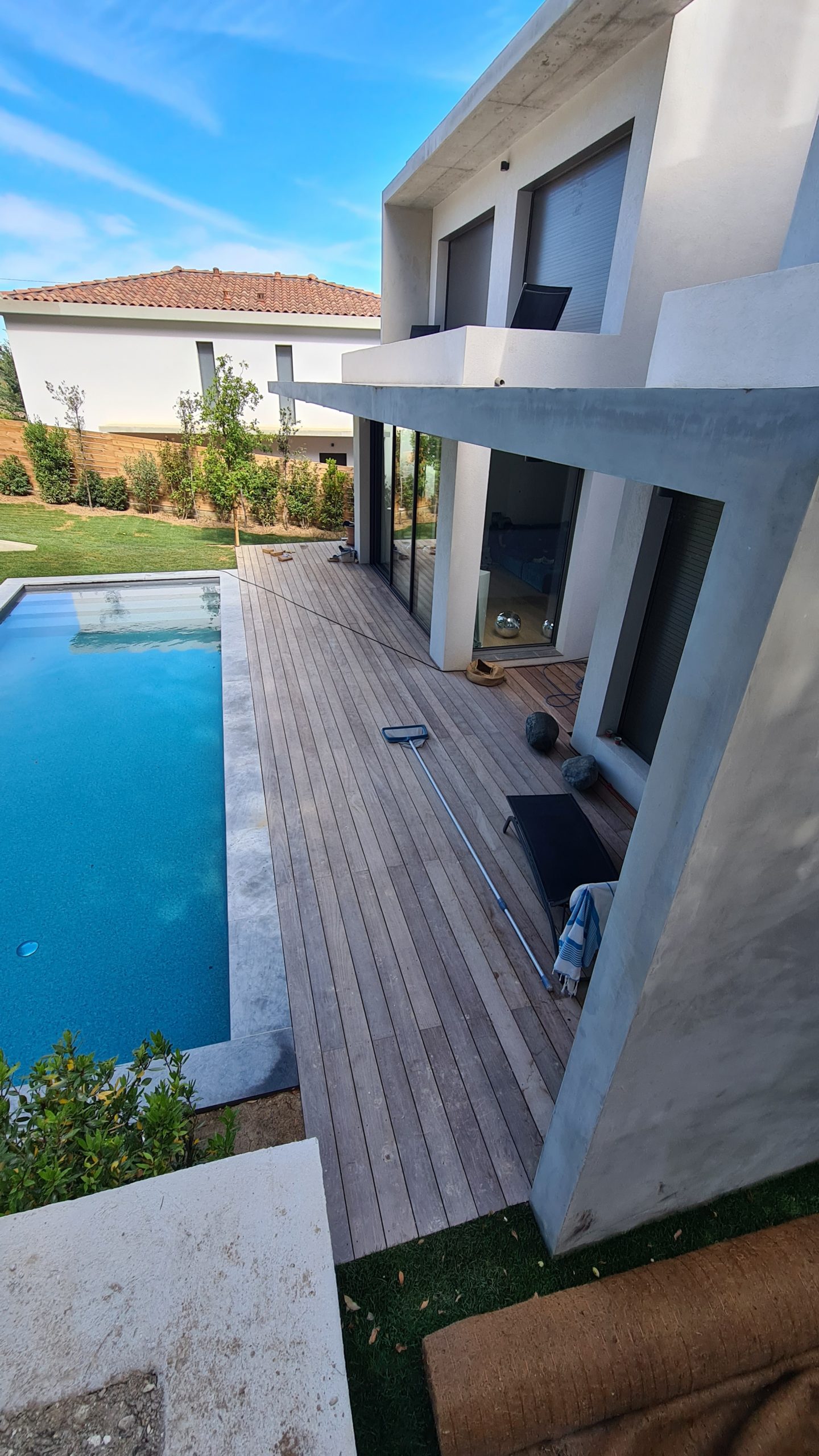 Terrasse en bois avec piscine dans une villa, vu de haut